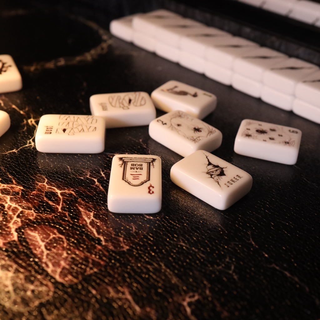 White mahjong tiles with black printed characters and symbols scattered on a dark textured surface, with a row of tiles arranged in the background.