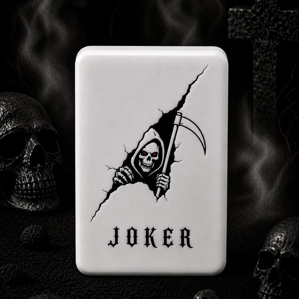 A white mahjong tile with rounded corners featuring a black graphic of a grim reaper tearing through the surface and the word 'JOKER' below, set against a dark gothic background with skulls and smoke.